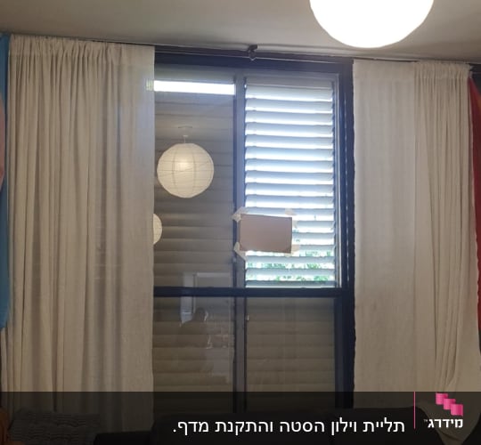 חלון עם תריסים וקרטון מודבק